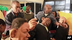 FILE - 'XYZ Show' creator Godfrey 'Gado' Mwampembwa (r) prepares the puppets for the show at his studio in Nairobi, Kenya, 21 May 2009.