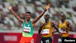 Gold medallist Selemon Barega of Ethiopia celebrates after crossing the line to win ahead of silver medallist, Joshua Cheptegei of Uganda and bronze medallist, Jacob Kiplimo of Uganda.