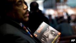 James R. Johnson hands out programs before the Rev. Martin Luther King Jr. holiday commemorative service at Ebenezer Baptist Church, Jan. 16, 2017, in Atlanta.