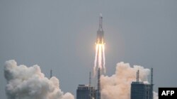 A Long March 5B rocket, carrying China's Tianhe space station core module, lifts off from the Wenchang Space Launch Center in southern China's Hainan province on April 29, 2021. (Photo by STR / AFP) / China OUT