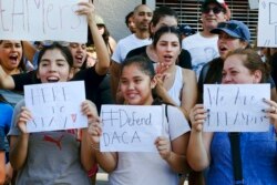 FILE - Supporters of the Deferred Action for Childhood Arrivals, or DACA, chant slogans and holds signs while joining a Labor Day rally in downtown Los Angeles, Sept. 4, 2017.