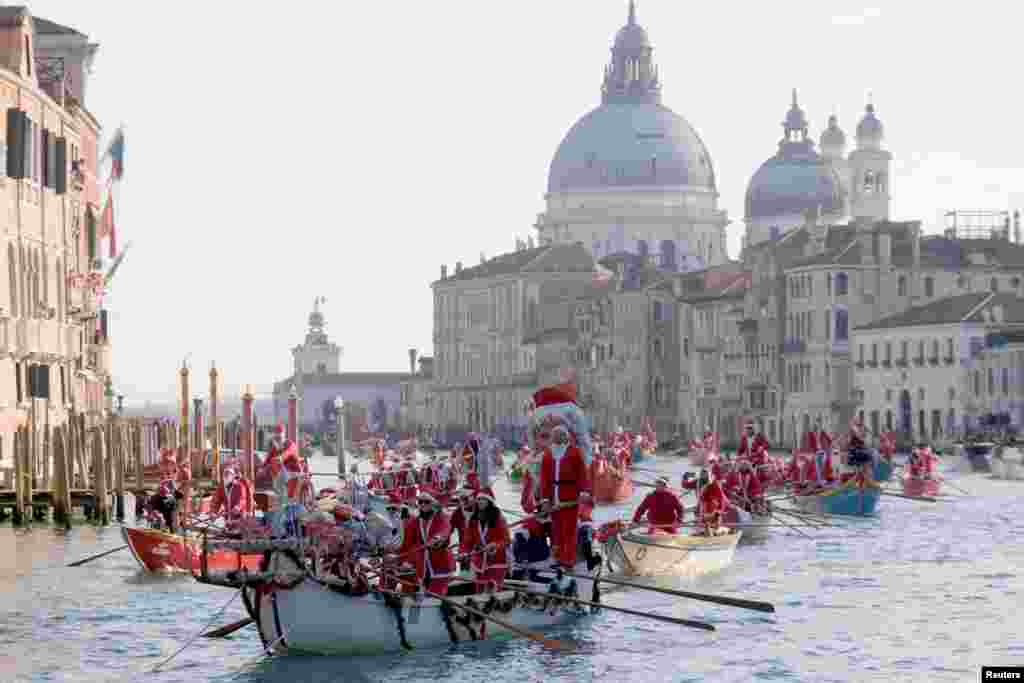 People dressed as Santa Claus row during a Christmas regatta along the Grand Canal in Venice, Italy.