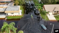 A member of the Pasco County Sheriff's Office goes out to help residents trapped in their homes as waters rise after Hurricane Milton caused the Anclote River to flood, Oct. 11, 2024, in New Port Richey, Fla.