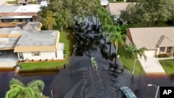 A member of the Pasco County Sheriff's Office goes out to help residents trapped in their homes as waters rise after Hurricane Milton caused the Anclote River to flood, Oct. 11, 2024, in New Port Richey, Fla.