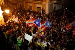 People react after Puerto Rican Governor Ricardo Rossello broadcasted his resignation, in San Juan, Puerto Rico, July 25, 2019.