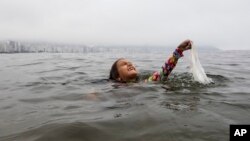 Nina Gomez duke nxjerrë një qese plastike nga deti pranë Rio de Janeiros, Brazil