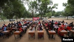 FILE - Members of the Bring Back Our Girls campaign group sit behind tags with names of some of the remaining kidnapped Chibok school girls during the 5th year anniversary of their abduction, in Abuja, Nigeria, April 14, 2019.