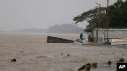 A man rides his bicycle alongside the Tecolutla River before the arrival of Hurricane Katia, in Tecolutla, Veracruz state, Mexico, Sept. 8, 2017. 