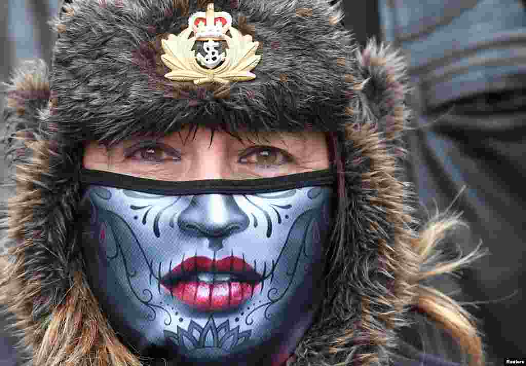 A woman wearing a protective face mask joins former British armed forces members and supporters at a "Respect Our Veterans" parade and rally in London, May 8, 2021.