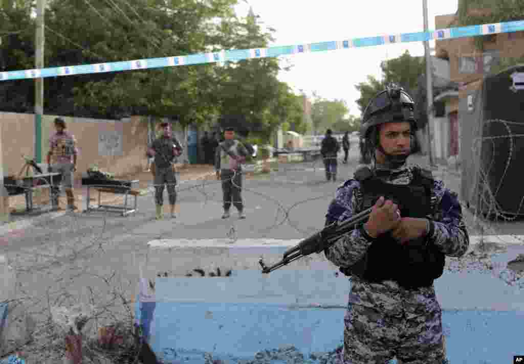 Security forces stand guard outside a polling center in Baghdad, Iraq, April 28, 2014.