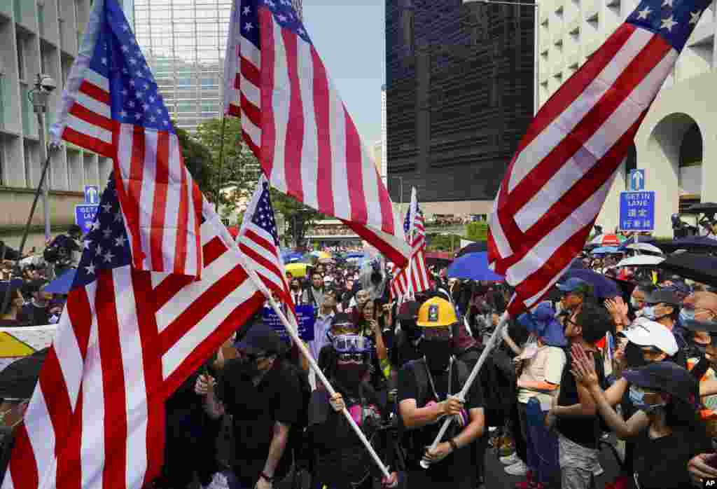 Otro vistazo de manifestantes en Hong Kong gritando consignas y ondeando banderas de Estados Unidos mientras marchan al Consulado de Estados Unidos, el domingo 8 de septiembre de 2019. (Foto AP / Vincent Yu)