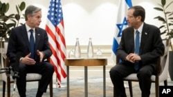 Israel's President Isaac Herzog, right and U.S. Secretary of State Antony Blinken hold a meeting in Tel Aviv, Israel, Thursday, Nov. 30, 2023, following the announcement of an extension of the truce between Israel and Hamas just before it was due to expire.