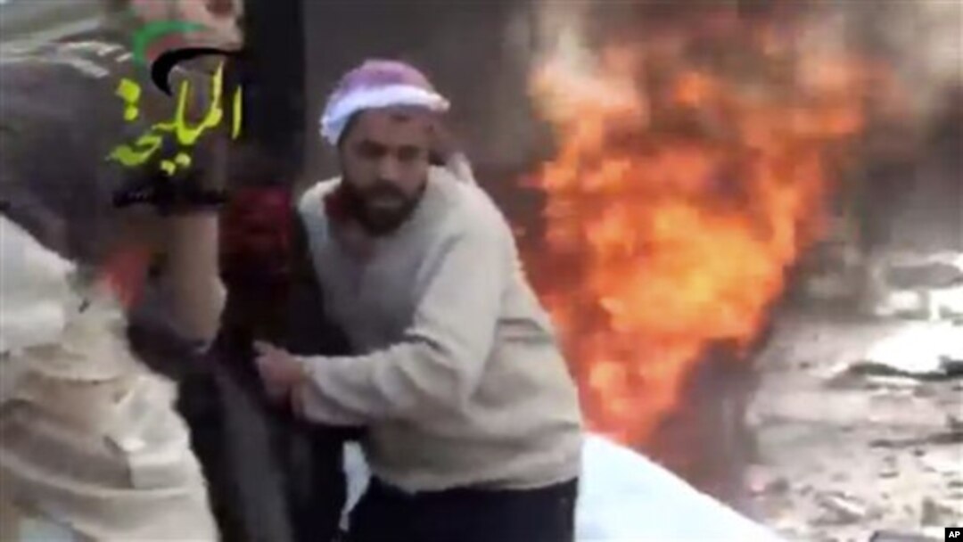 This image provided by Shaam News Network, which has been authenticated, shows a wounded man being pulled from the site of a Syrian government airstrike on a gas station in the eastern Damascus suburb of Mleiha, Syria, Jan. 2, 2013. 