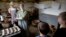 FILE - Hannah Ingersoll (L) and Loralei Arndt (2nd-L) reenact 1830s farm workers as children look on in a cheese room at Old Sturbridge Village, in Sturbridge, Mass., Aug. 22, 2018. 