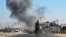 A man cycles as behind smoke from Israeli bombardment rises in an area that was ordered to be evacuated by the Israeli army in the southeast of Khan Yunis in the southern Gaza Strip, Sept. 8, 2024.