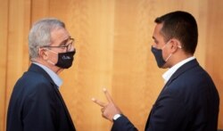 FILE - Malta's Foreign Minister Evarist Bartolo and his Italian counterpart Luigi Di Maio wear protective masks as they talk to each other during the EU foreign ministers' meeting in Berlin, Germany, Aug. 27, 2020. (Kay Nietfeld/Pool via Reuters)