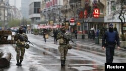 Tentara Belgia dan polisi berpatroli di pusat kota Brussel (21/11). Belgia memperketat pengamanan di Belgia menyusul serangan di Paris pekan lalu.