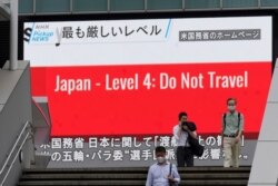 25일 일본 도쿄에 거리에 설치된 대형 화면에서 미국의 '여행 금지' 권고 관련 뉴스가 나오고 있다.