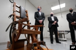 فرماندار ویرجینیا در کنار یک صندلی الکتریکی که از آن برای مجرمان محکوم به اعدام استفاده می‌شد.