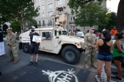 Demonstrators talk to National Guard soldiers as they protest Saturday, June 6, 2020, near the White House in Washington, over the death of George Floyd, a black man who was in police custody in Minneapolis.