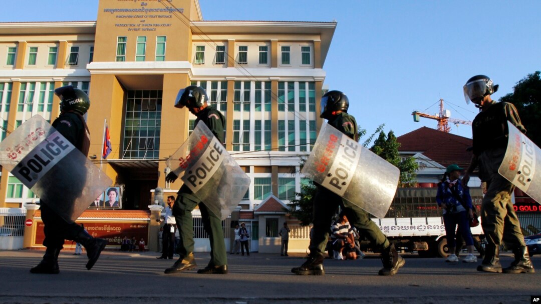FILE - Cambodian riot police officers walk in front of Phnom Penh Municipality Court in Phnom Penh, Cambodia. Police set up a roadblock Monday about 500 meters from the headquarters of the opposition Cambodia National Rescue Party.