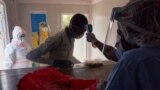 FILE - A suspected COVID-19 patient's temperature is measured as he is admitted at the isolation ward of Ministry of Health Infectious Disease Unit in Juba, South Sudan, April 24, 2020.