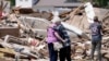 ARCHIVO - Joan Mitchell, izquierda, recibe un abrazo de su vecina Edith Schaecher frente a sus casas dañadas por el tornado, el jueves 23 de mayo de 2024, en Greenfield, Iowa.