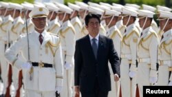Japan's Prime Minister Shinzo Abe reviews the honor guard before a meeting with Japan Self-Defense Force's senior members at the Defense Ministry in Tokyo, Sept. 12, 2013. 
