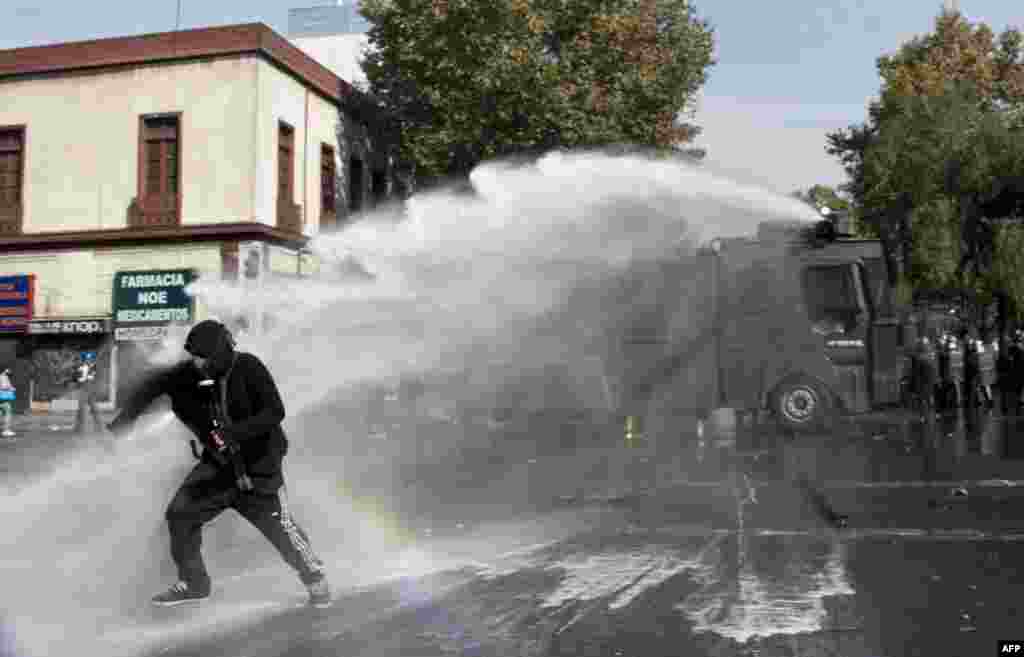 Para demonstran bentrok dengan polisi dalam demonstrasi Hari Buruh di Santiago, Chile. 