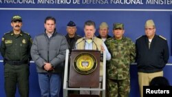 FILE - Colombia's President Juan Manuel Santos, center, speaks during a news conference in Bogota, Nov. 16, 2014. 