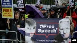 Supporters hold placards and banners during a protest against the extradition of Wikileaks founder Julian Assange outside Belmarsh Magistrates Court in London, Monday, Feb. 24, 2020.