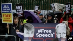 Des partisans brandissent des pancartes et des banderoles lors d'une manifestation contre l'extradition du fondateur de Wikileaks, Julian Assange, devant le Belmarsh Magistrates Court à Londres, le lundi 24 février 2020. (AP)