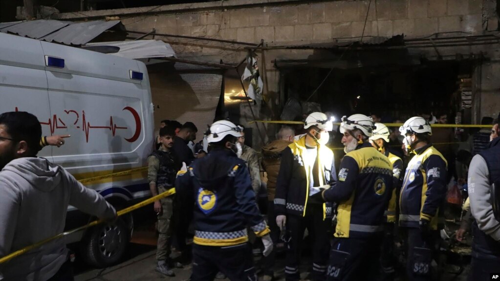 Trabajadores de los Cascos Blancos buscan víctimas tras la explosión de un coche bomba en un bullicioso mercado el domingo 31 de marzo de 2024 en la madrugada, en Azaz, Siria, una ciudad noroccidental controlada por Turquía. [Cascos Blancos/Defensa Civil Siria vía AP]