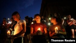 Samuel Lerma, Arzetta Hodges and Desiree Qunitana join mourners at a vigil at El Paso High School after a mass shooting at a Walmart store in El Paso, Texas, Aug. 3, 2019.