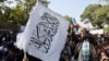  FILE - An Afghan student waves a white Taliban flag at a rally in Kabul, Afghanistan, Oct. 25, 2014.