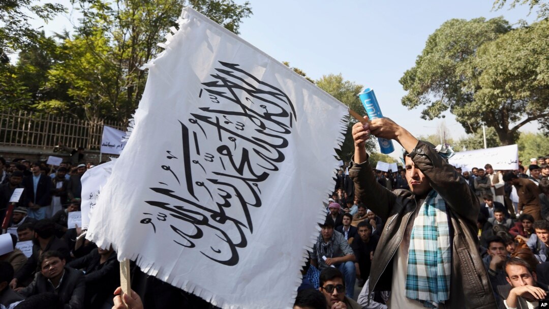  FILE - An Afghan student waves a white Taliban flag at a rally in Kabul, Afghanistan, Oct. 25, 2014.
