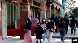资料照片：不丹人戴着防范新冠病毒扩散的口罩走在首都廷布的街头。(2021年4月12日)