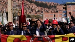 El presidente boliviano Luis Arce, centro, grita consignas durante la marcha del Primero de Mayo o Día del Trabajo en La Paz, el lunes 1 de mayo de 2023. El segundo desde la izquierda es Juan Carlos Huarachi, líder del principal Sindicato de Trabajadores del país.