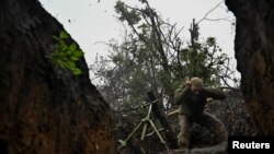 A Ukrainian serviceman fires a mortar toward Russian troops in a front line in Donetsk region