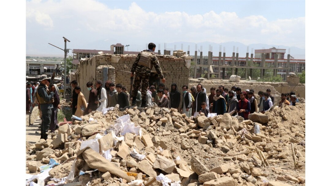Security personnel and residents gather at the site of a car bomb attack in the Pul-e-Alam area of Logar province, Afghanistan, May 1, 2021.