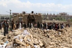 Security personnel and residents gather at the site of a car bomb attack in the Pul-e-Alam area of Logar province, Afghanistan, May 1, 2021.