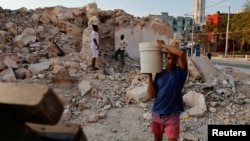 (FILE) Lazaro Alvares, 24, salvages contruction materials from a collapsed building to resell. Havana, Cuba.