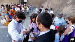 Tourists have their Green Pass checked by keepers at the entrance of the Vatican Museums, Aug. 6, 2021. 