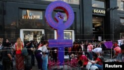  Activists and relatives place pink crosses at a makeshift monument against femicide with names of the states of Mexico, during a protest against femicide and violence against women, in Mexico City, March 24, 2019. The sign reads: "No more femicides."