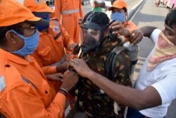 A National Disaster Response Force (NDRF) soldier is fitted with gear before he proceeds to the area from where chemical gas leaked in Vishakhapatnam, India, May 7, 2020.