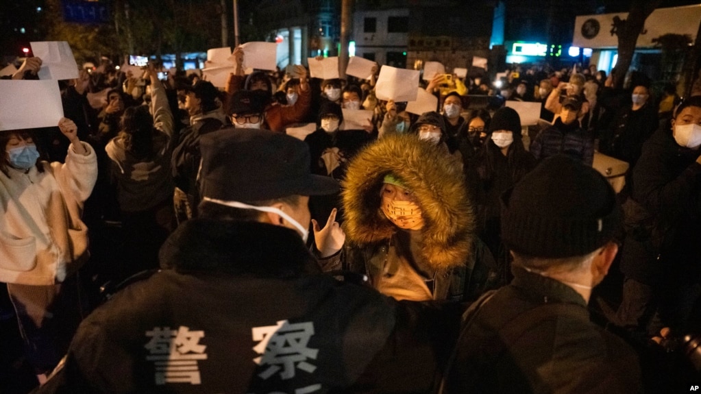 2022年11月27日，北京一些抗议人士手举表达不满的白纸与警察对峙。周末中国好几个地方发生了街头抗议。这些抗议的爆发随然令人意外，但作为统治者的中共甚至早在1989年“六四”血腥镇压学生抗议示威之后就一直在防备类似事件再次出现。(photo:VOA)
