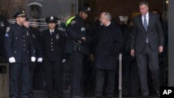 New York Police Commissioner Bill Bratton, second from right, shakes hands with an officer alongside New York City Mayor Bill de Blasio, right, as they exit the wake of Officer Wenjian Liu at Aievoli Funeral Home in Brooklyn, New York, Jan. 3, 2015.