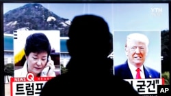 지난 10일 한국 서울역에 설치된 TV에서 박근혜 대통령(왼쪽)이 도널드 트럼프 미국 대통령 당선인(오른쪽)과 통화했다는 뉴스가 나오고 있다.