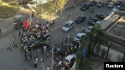 Security officers surround a car carrying U.S. ambassador Gary Locke after anti-Japan demonstrators tried to block the car outside the U.S. embassy in Beijing, September 18, 2012.