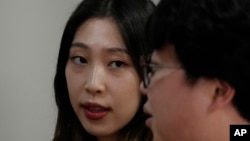Yoo Young Yi watches her husband Jo Jun Hwi as he speaks during an interview at their home in Seoul, South Korea on October 2, 2022. (AP Photo/Ahn Young-joon)